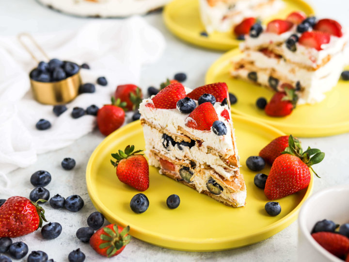 layered cake with berries on yellow plate