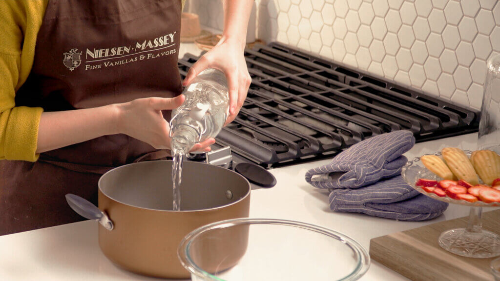 Pouring water into a pot to create a double boiler