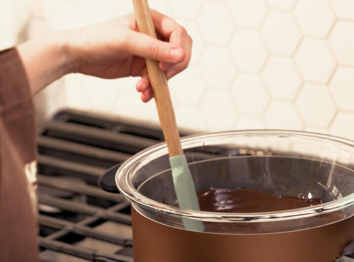 Tempering chocolate by stirring chocolate in a double boiler