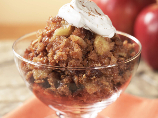 Bowl of apple pudding with a dollop of whipped cream